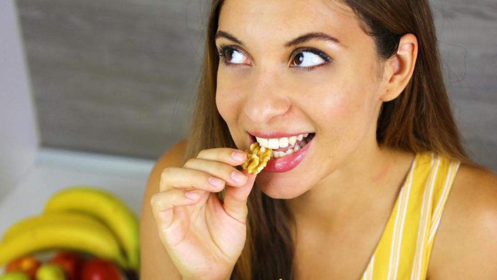 Mujer comiendo nueces.