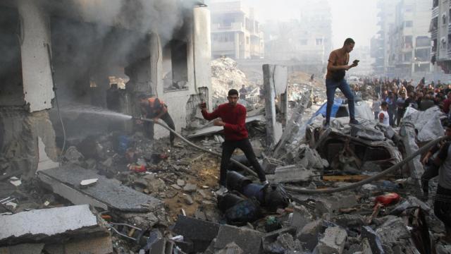 Palestinos inspeccionan los daños en una escuela que alberga a  desplazados tras ser alcanzada este jueves por un ataque israelí en la ciudad de Gaza.