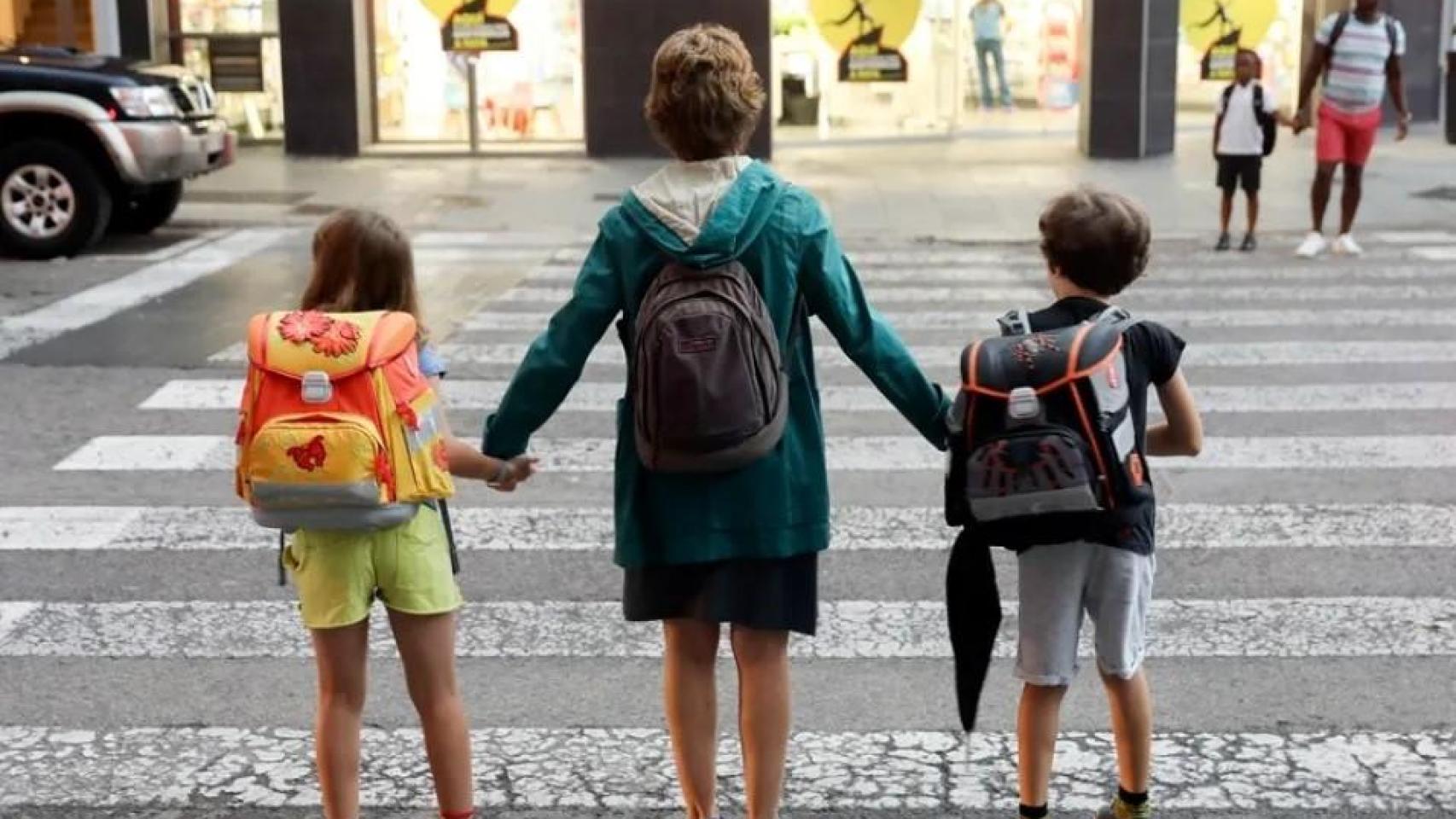 Una madre lleva a sus dos hijos al colegio durante el primer día de curso escolar en Valencia. EFE/ Kai Forsterling/Archivo