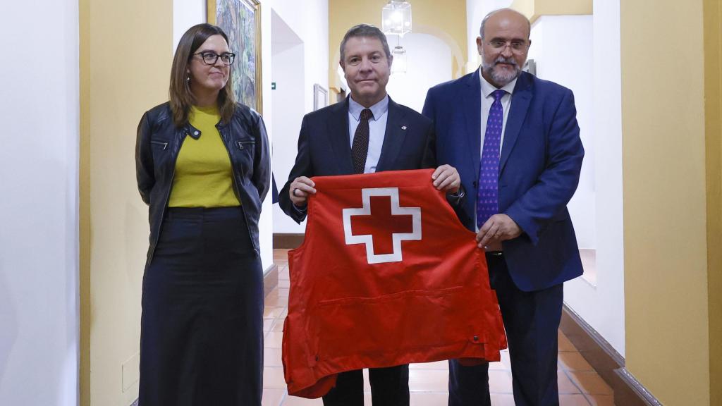 Emiliano García-Page, posa con un chaleco de Cruz Roja este jueves en las Cortes de Castilla-La Mancha junto a Esther Padilla y José Luis Martínez Guijarro.