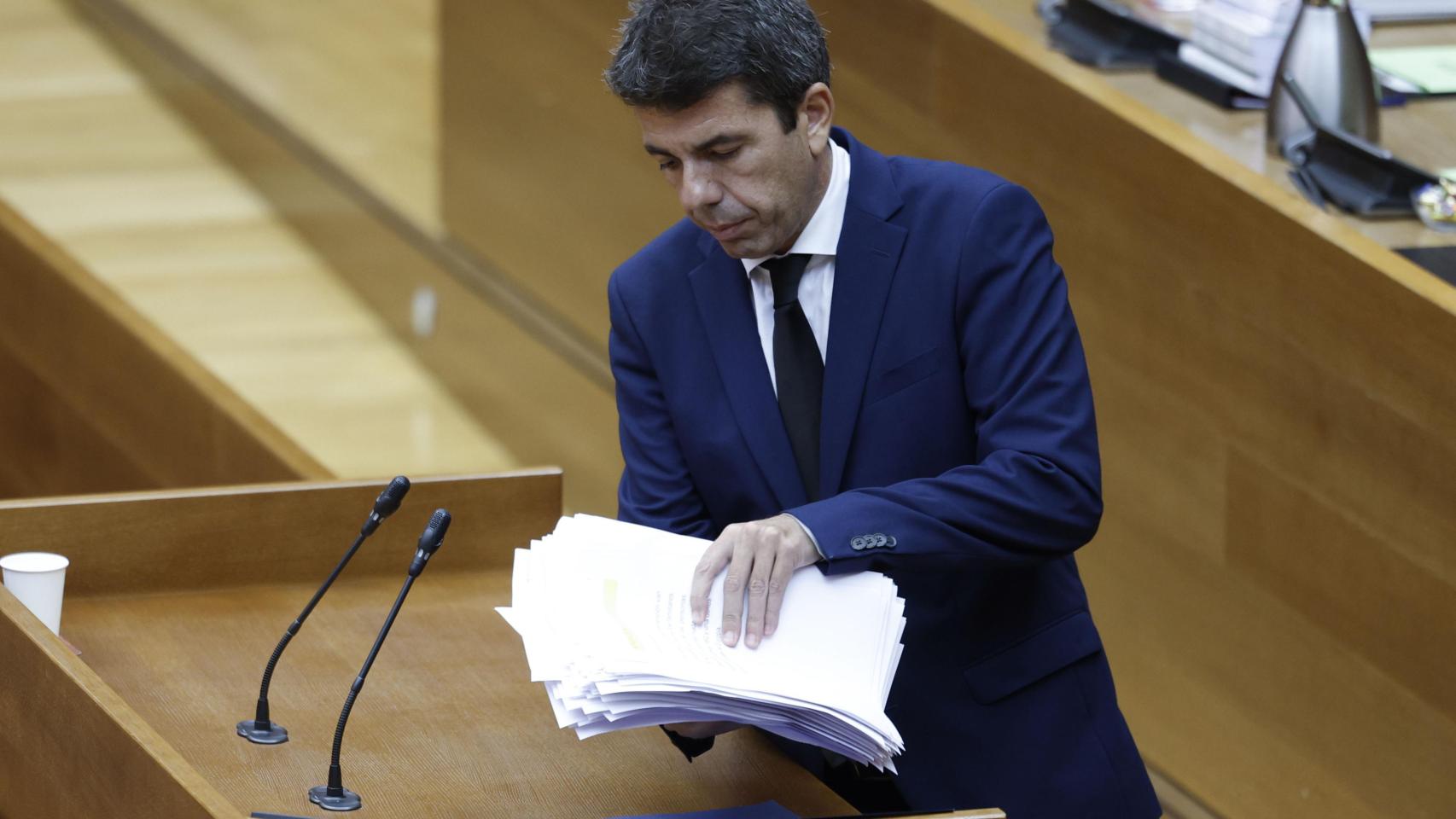 El presidente de la Generalitat, Carlos Mazón, recoge sus papeles tras comparecer en Les Corts durante el pleno de este viernes. Efe / Biel Aliño