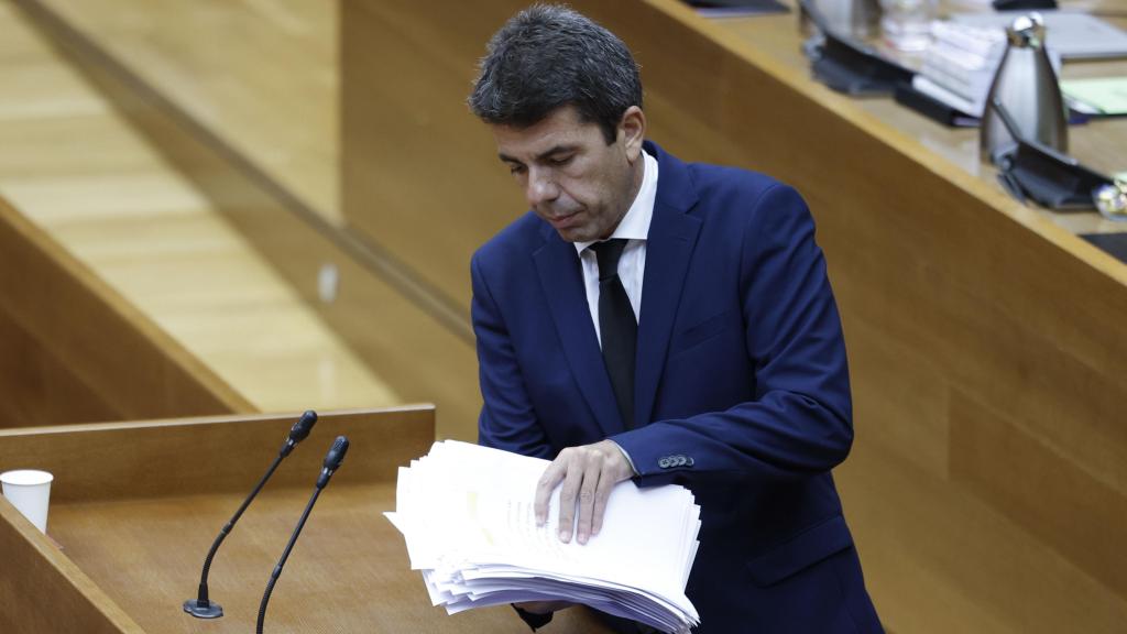 El presidente de la Generalitat, Carlos Mazón, recoge sus papeles tras comparecer en Les Corts durante el pleno de este viernes. Efe / Biel Aliño