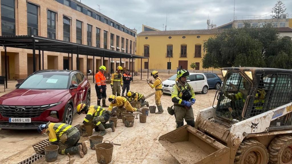 Trabajadores de INFOAR retiran lodo del colector de aguas en la plaza Mayor de Catarroja.