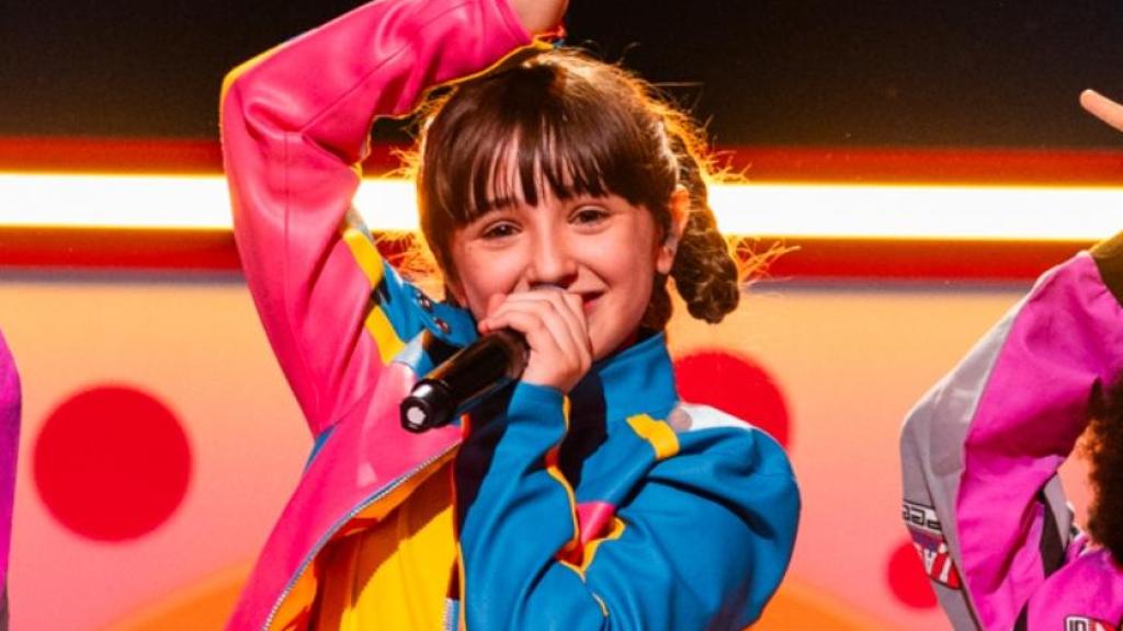 Andria Putkaradze alzándose con el 'mini' Micrófono de Cristal y Chloe DelaRosa en los ensayos de Eurovisión Junior 2024.