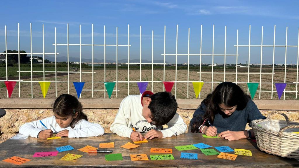 Niños escribiendo mensajes de apoyo en post-its.