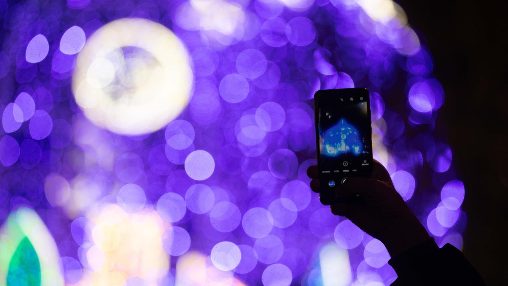 Una persona fotografía unas luces de Navidad.