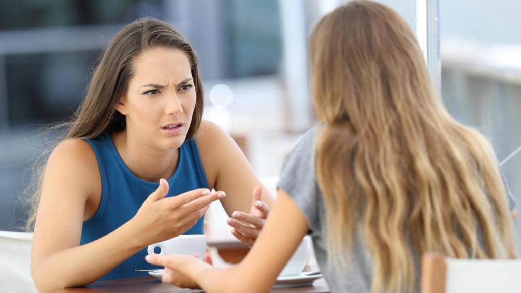 Mujeres dialogando con actitud molesta.