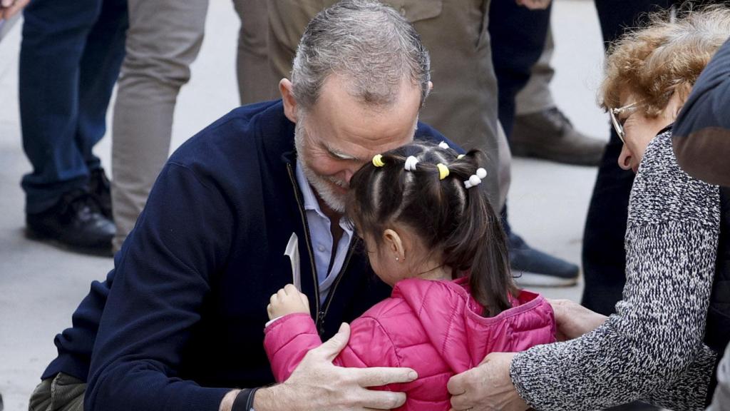 Felipe VI saluda a una niña en Chiva.