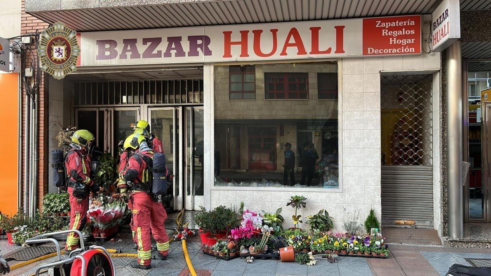 Los bomberos sofocando las llamas en el bazar que se ha incendiado