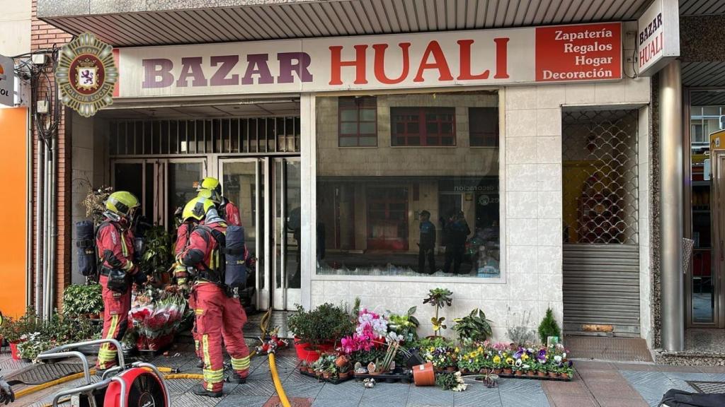 Los bomberos sofocando las llamas en el bazar que se ha incendiado