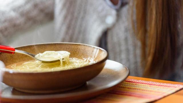 Una persona comiendo un plato de sopa