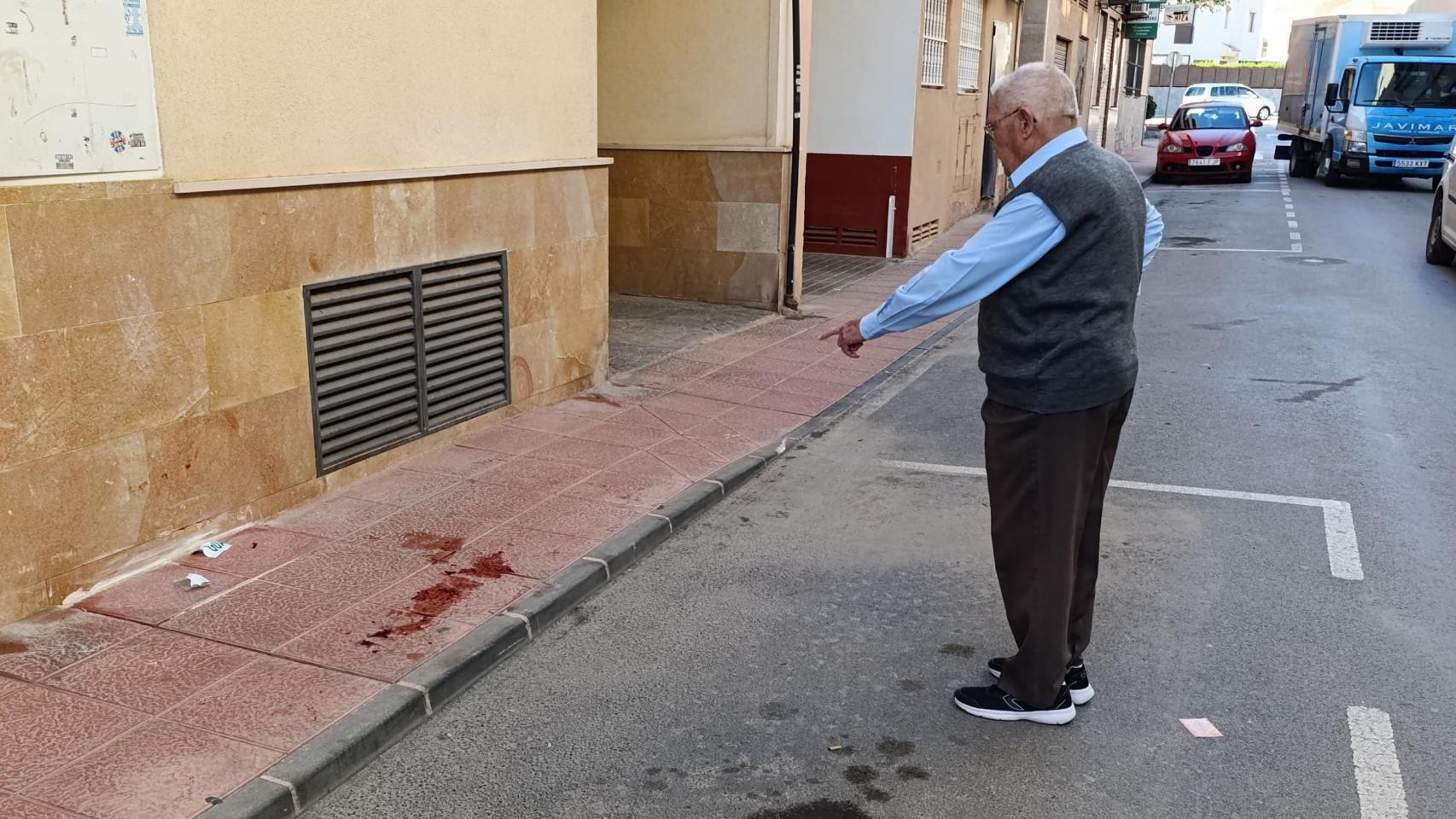 Un vecino de la calle donde dispararon a Aaron en Santiago de la Ribera muestra los restos de sangre del muchacho.