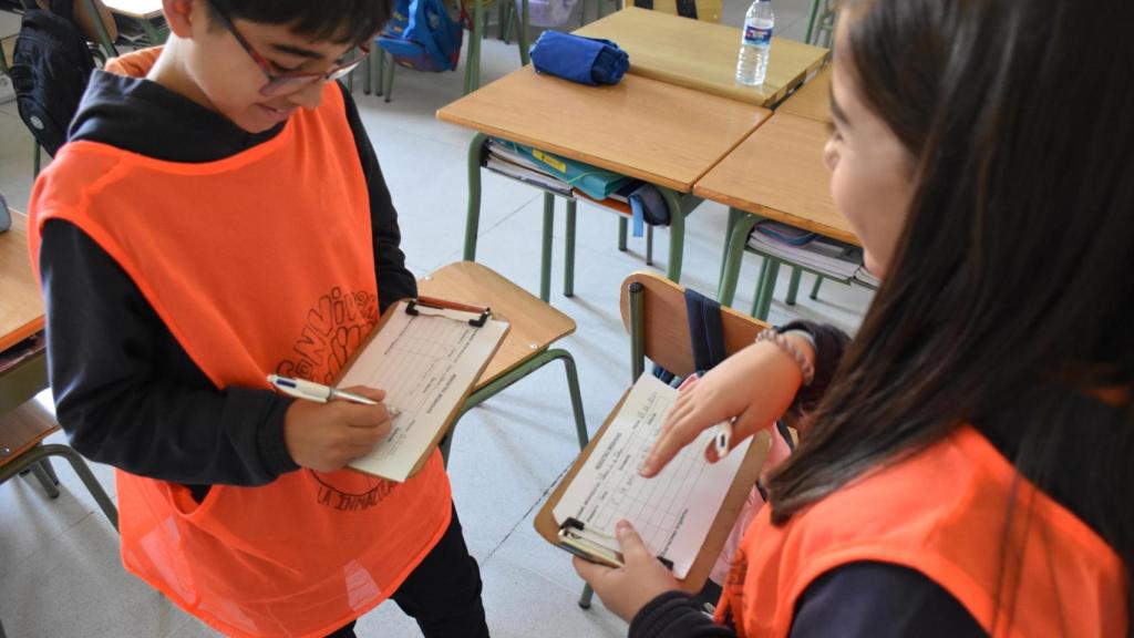 Izan y Valeria escribiendo en su hoja de registro