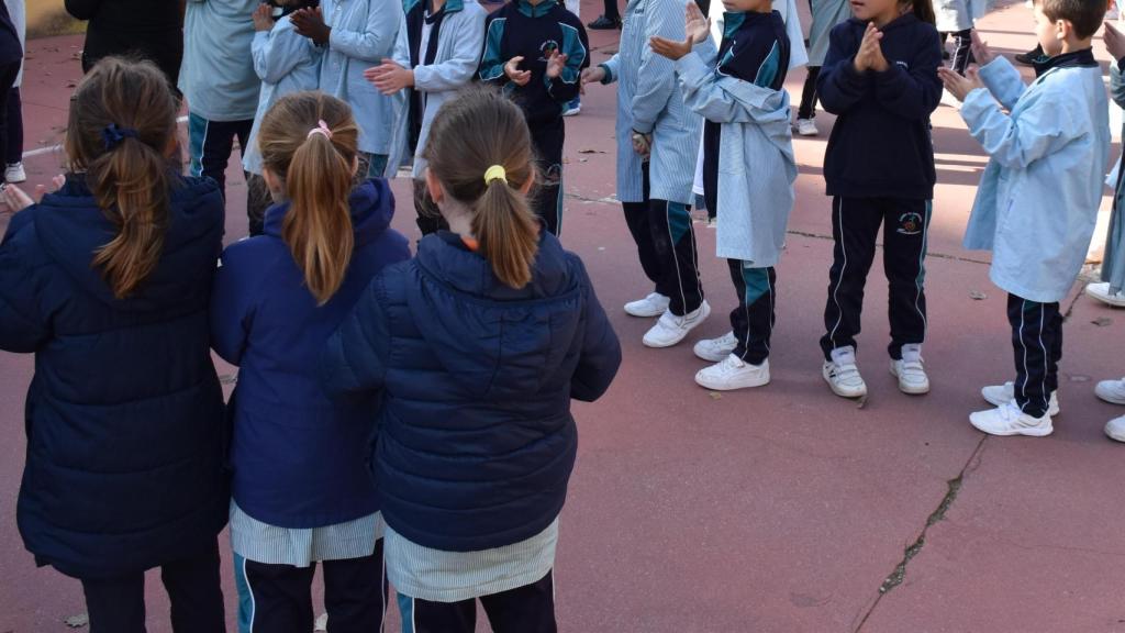 Varias filas de niños aplaudiendo antes de subir a clase del recreo