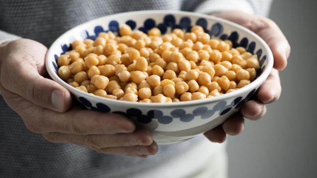 Mujer sosteniendo un cuenco con garbanzos.