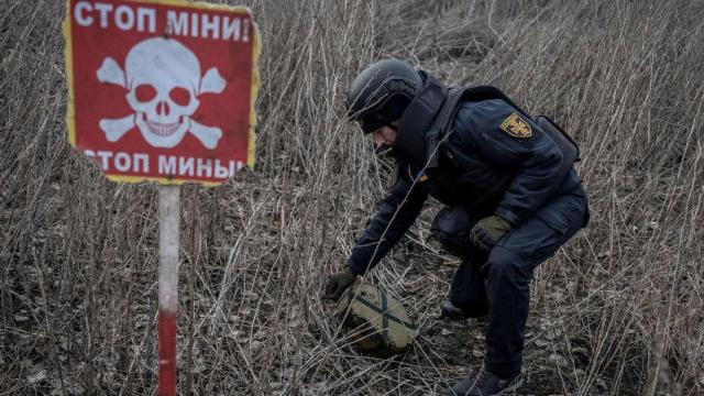 Un miembro del Servicio Estatal de Emergencias de Ucrania inspecciona un área en busca de minas sin explotar en Járkov en 2023.