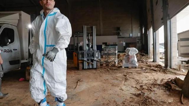 Trabajadores de una empresa de logística limpian el interior de una nave en el polígono industrial de Riba-roja de Túria. EFE/Manuel Bruque