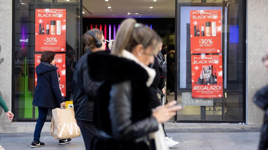 Varias personas frente a un comercio con ofertas del Black Friday.