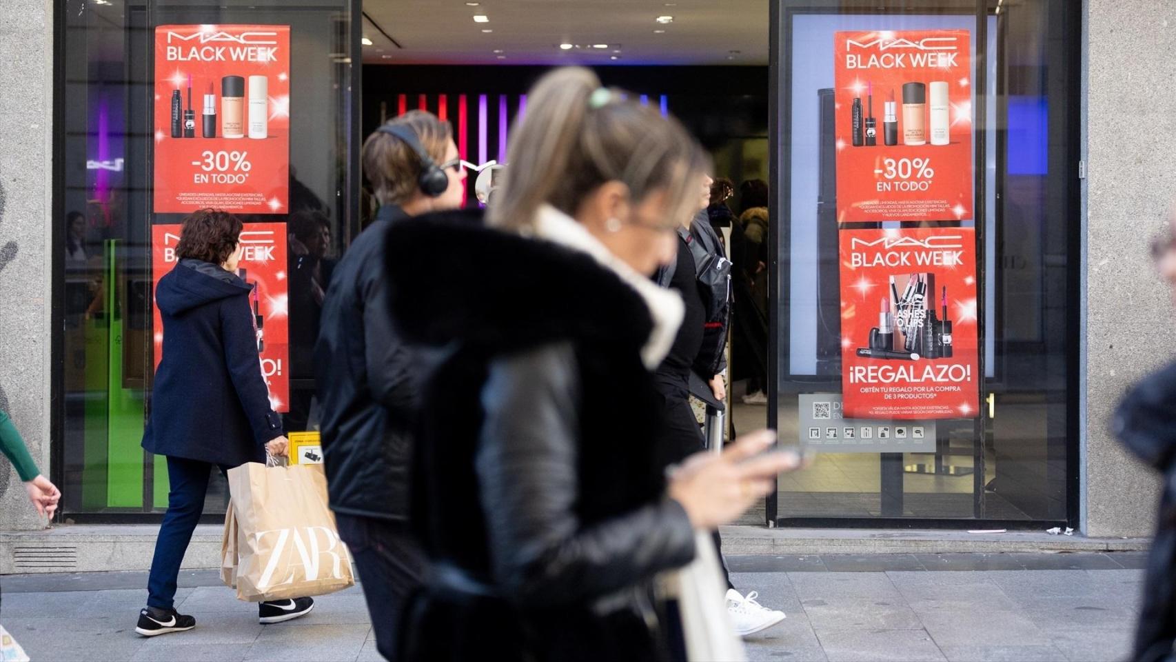 Varias personas frente a un comercio con ofertas del Black Friday.