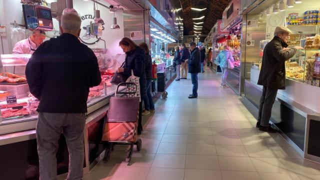 Varias personas haciendo sus compras en el Mercado del Val de Valladolid