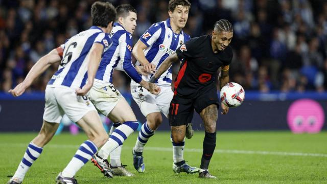 Raphinha trata de aguantar el balón ante la presión de tres jugadores de la Real Sociedad.