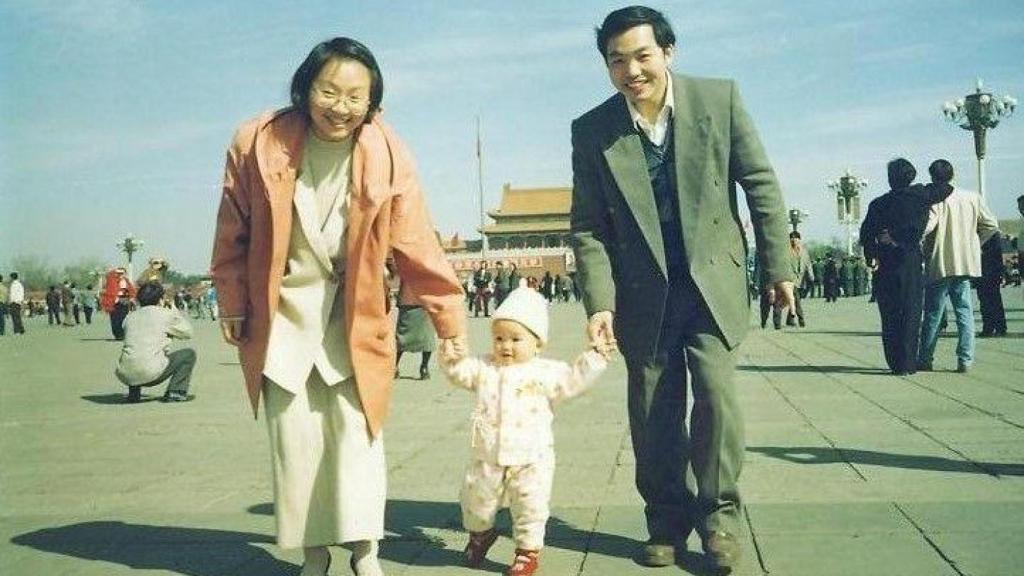 Ding Jiaxi y su esposa Sophie Luo cogen la mano de su hija en una vieja foto familiar.