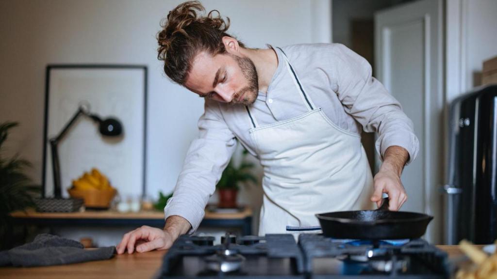 Hombre cocinando en su piso de alquiler.