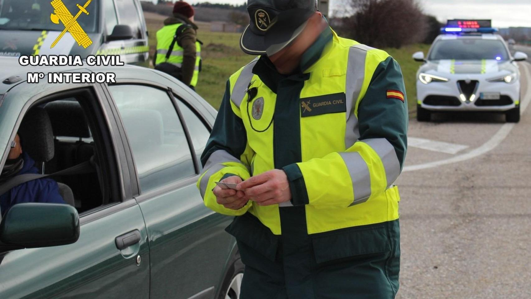 Un guardia civil comprobando la documentación de un conductor