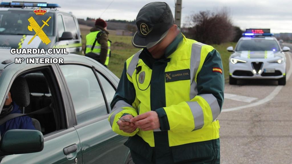 Un guardia civil comprobando la documentación de un conductor