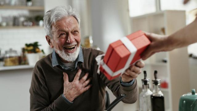 Imagen de archivo de un abuelo recibiendo un regalo.