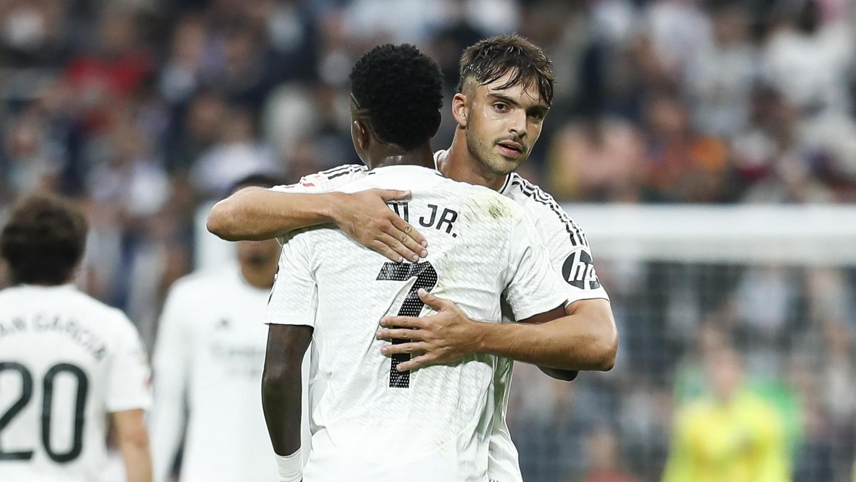 Vinicius y Raúl Asencio se abrazan en un partido del Real Madrid