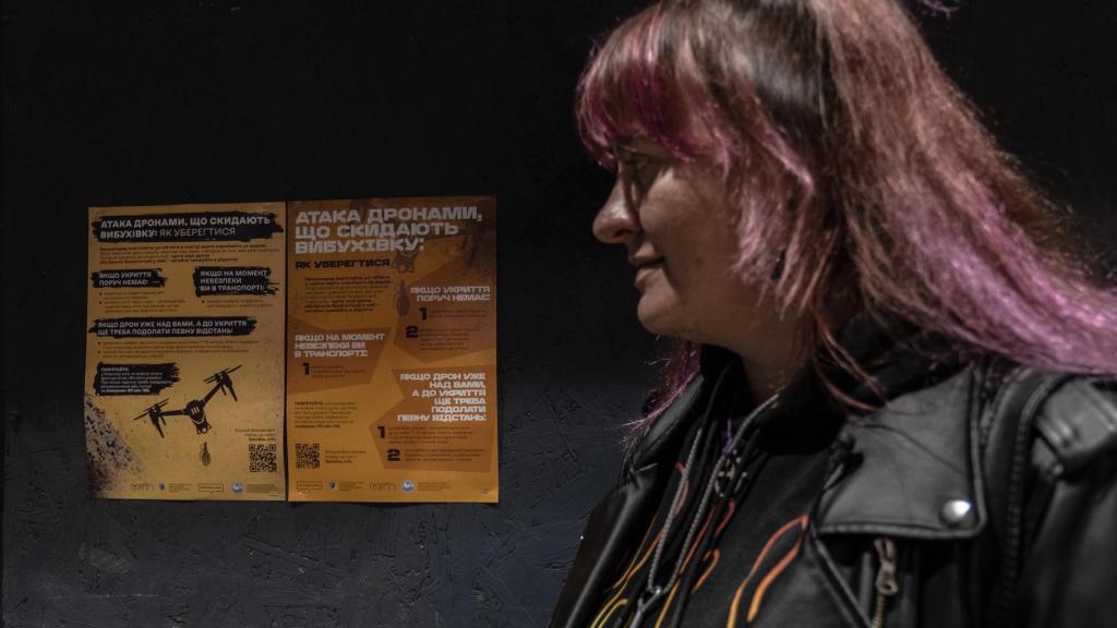 Olga posa junto a uno de los carteles que ha colocado en la ciudad de Jersón para enseñar a la población civil a protegerse de los ataques con drones.