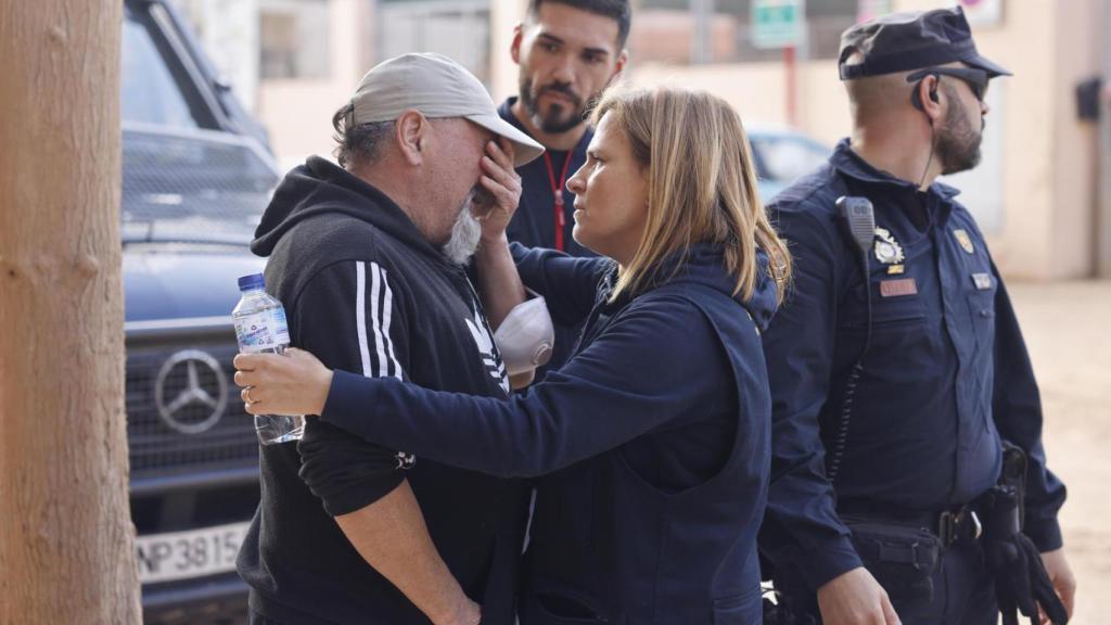 La delegada del Gobierno en Valencia, Pilar Bernabé, consuela a un vecino a su llegada este domingo al colegio Lluís Vives de Massanassa (Valencia).