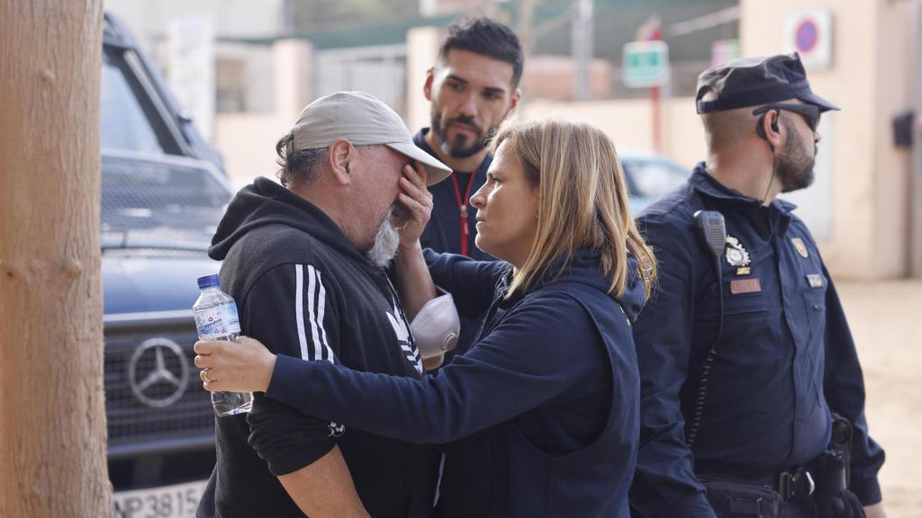 La delegada del Gobierno en Valencia, Pilar Bernabé, consuela a un vecino a su llegada este domingo al colegio Lluís Vives de Massanassa (Valencia).