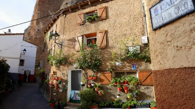 Fachada de una casa con flores en el pueblo Los Fayos.