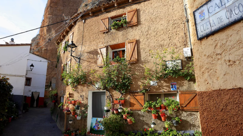 Fachada de una casa con flores en el pueblo Los Fayos.