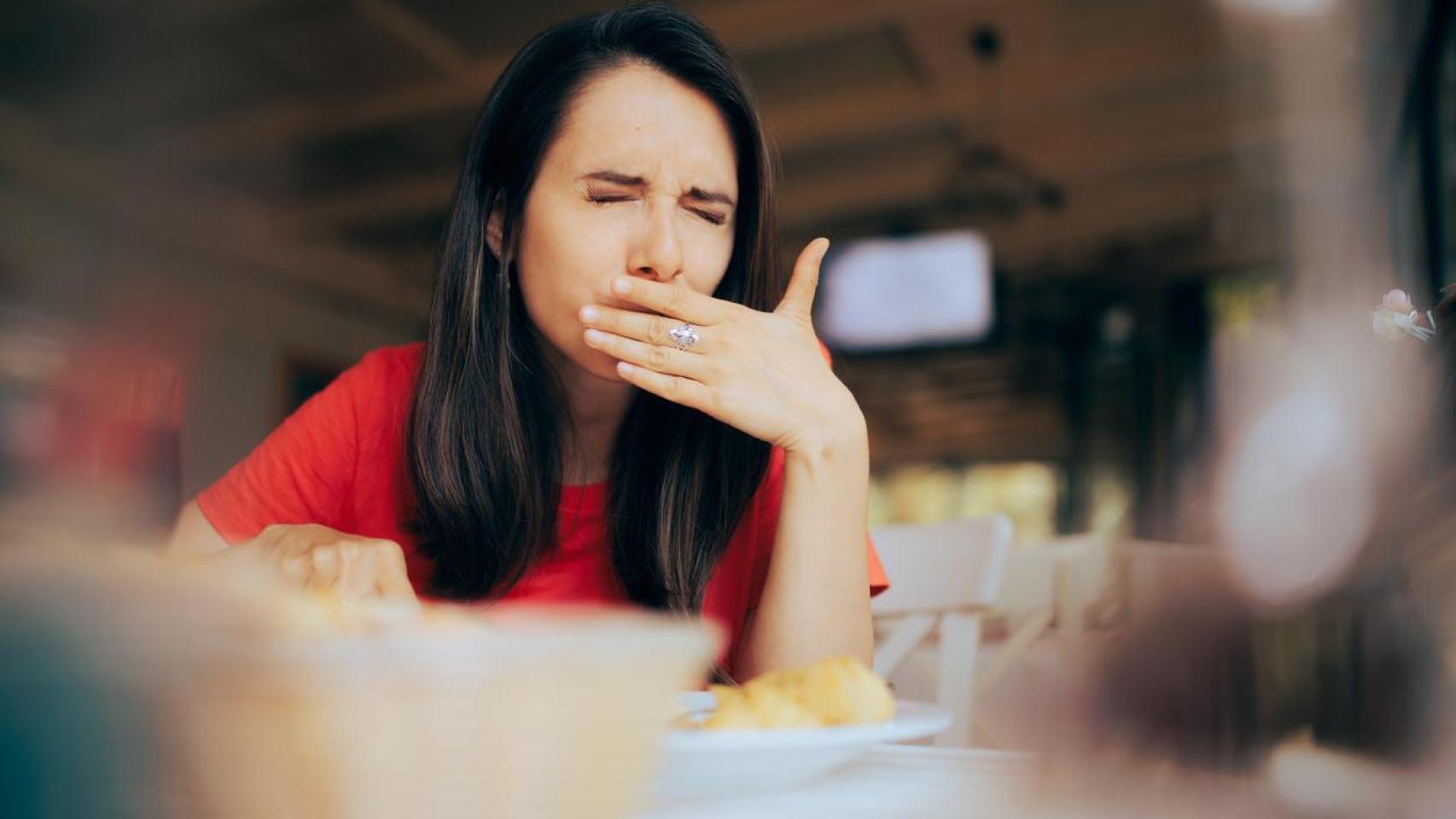 Mujer comiendo algo que no le está sentando bien.