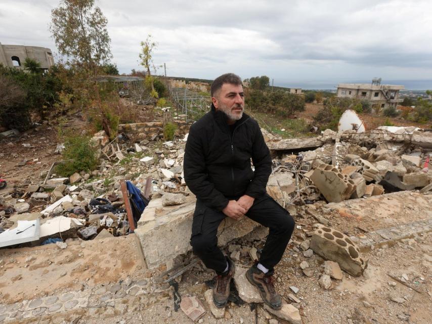 El desplazado libanés Assaad Bzih se sienta cerca de su casa destruida  en Zibqin tras la entrada en vigor del fuego entre Israel y Hezbolá.