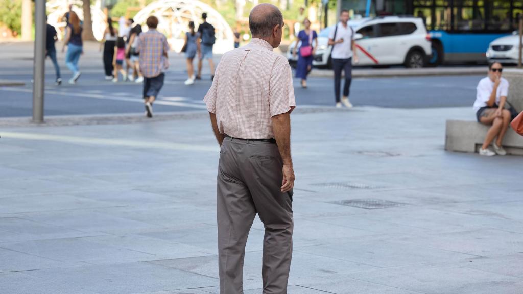 Un señor mayor camina por una calle de Madrid.