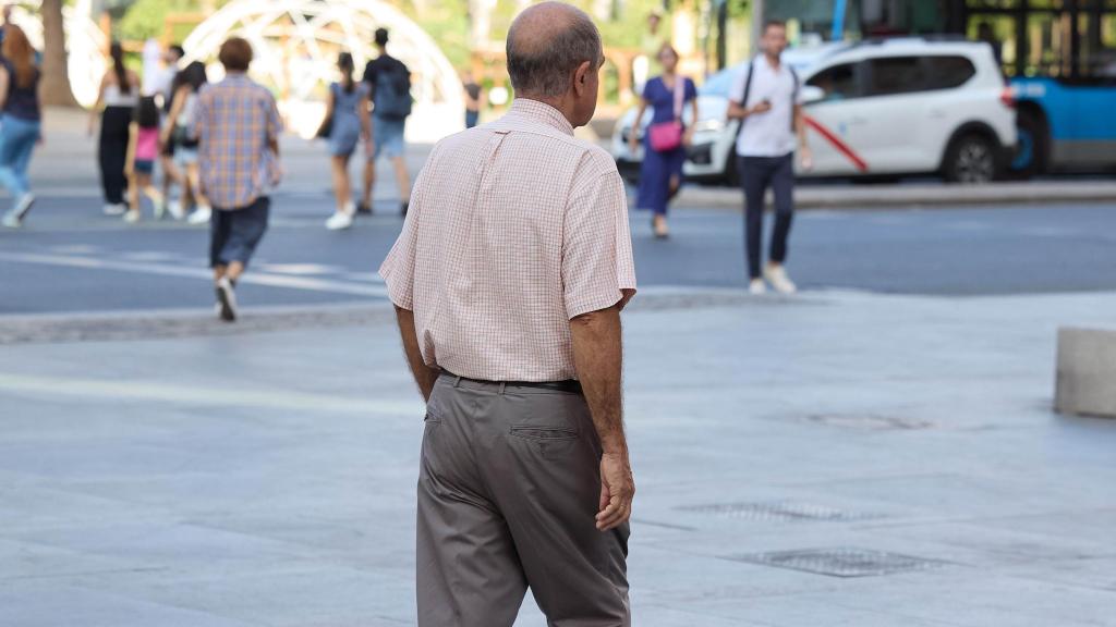 Un señor mayor camina por una calle de Madrid.