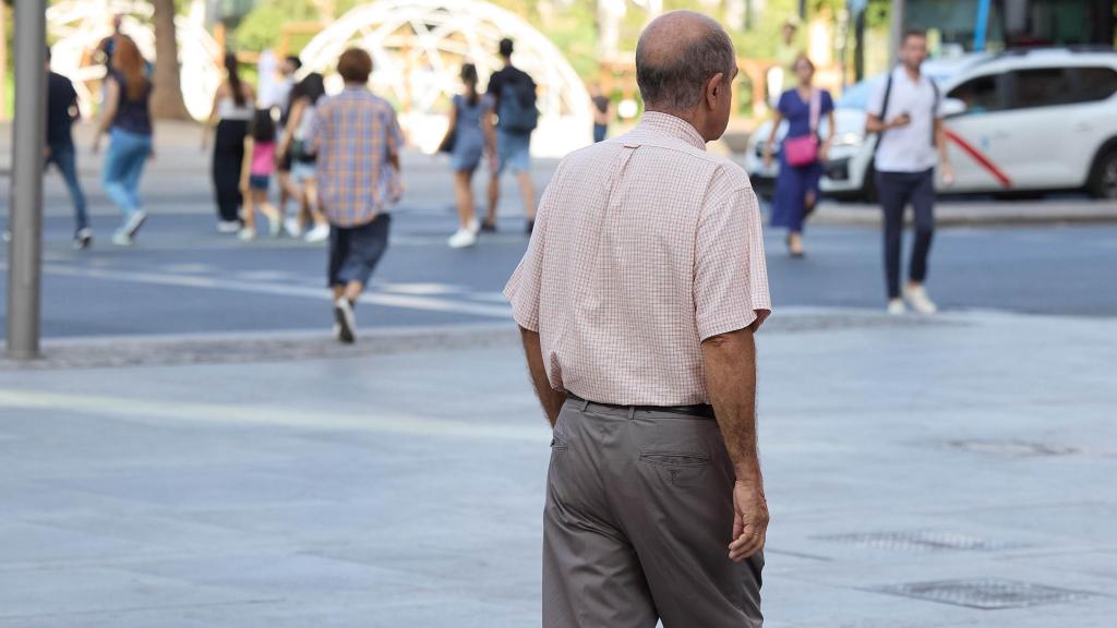 Un señor mayor camina por una calle de Madrid.