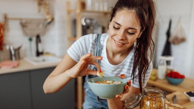 Mujer añadiendo ingredientes en un cuenco.