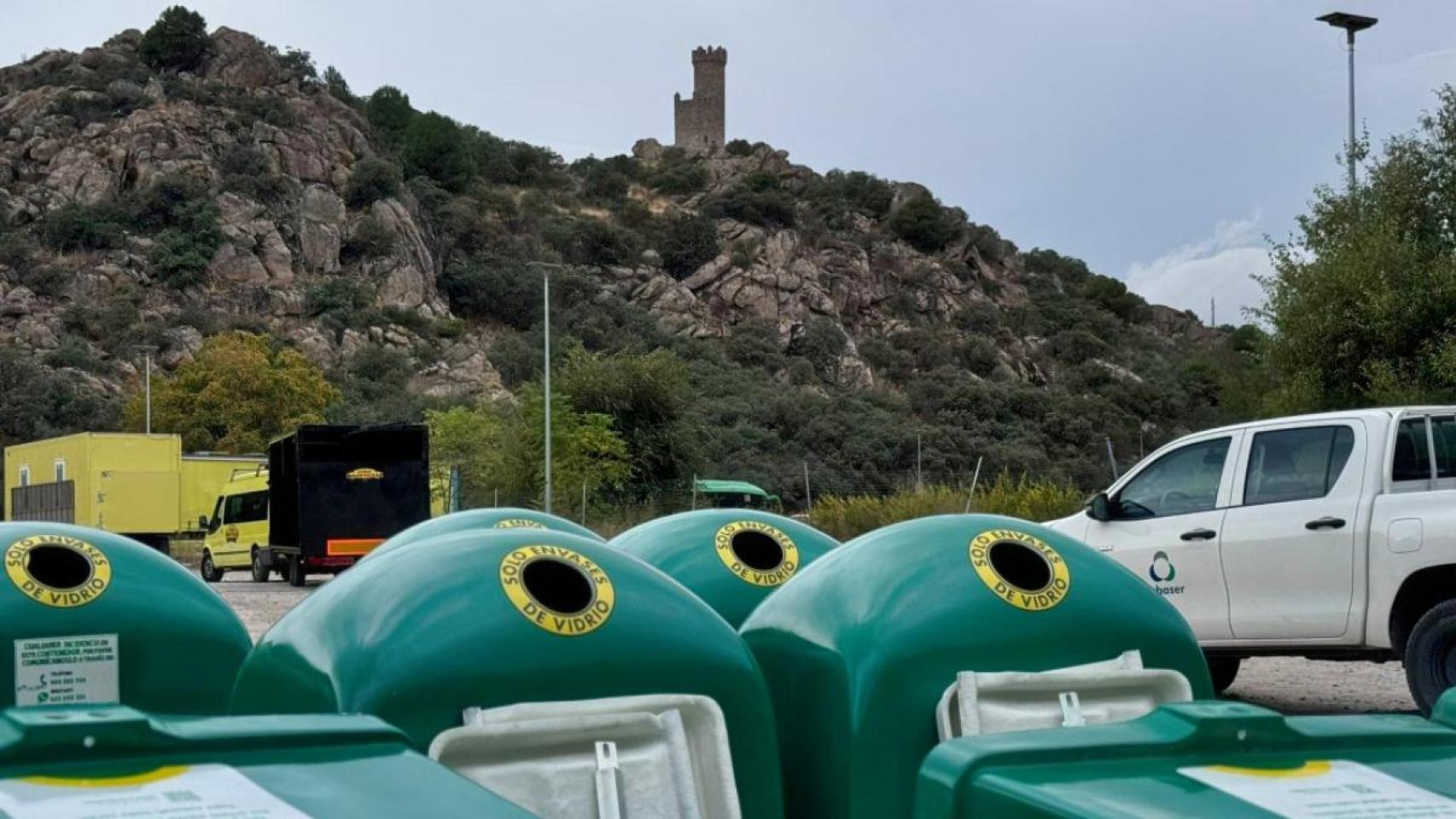 Contenedores de vidrio en Torrelodones, con la famosa atalaya del municipio de fondo.