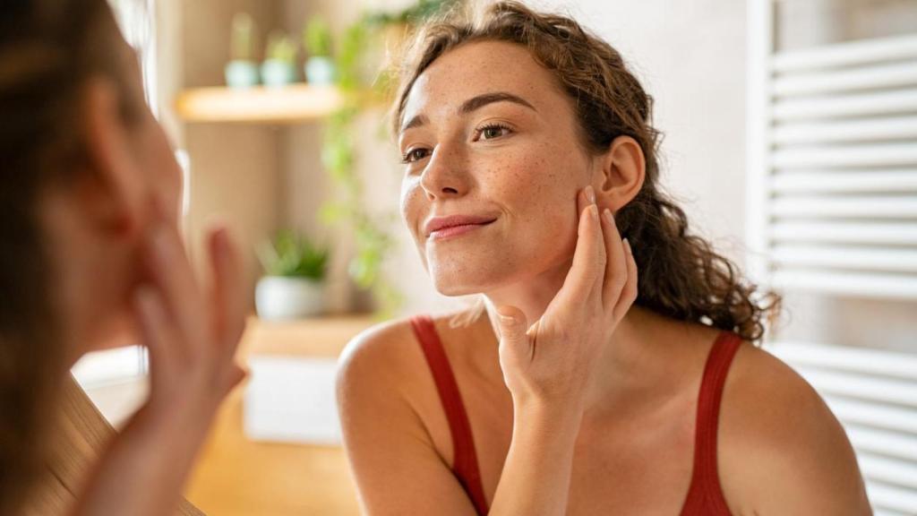 Mujer mirándose al espejo.