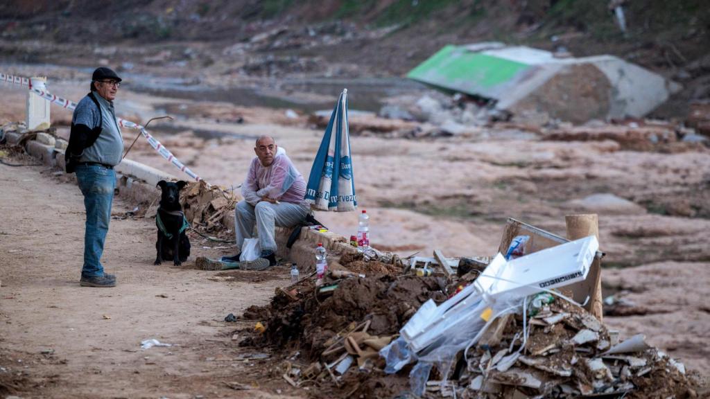 Dos personas conversan en el barranco del Poyo en Picanya, cuando se cumple un mes del paso de la DANA que arrasó parte de la zona. Efe / Biel Aliño