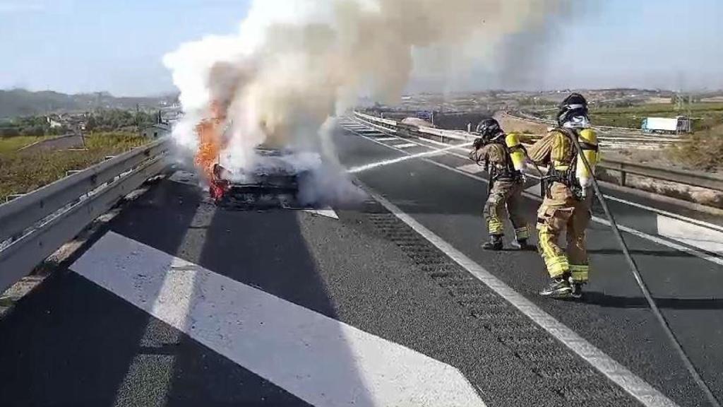 Bomberos trabajando en el incendio de un vehículo.