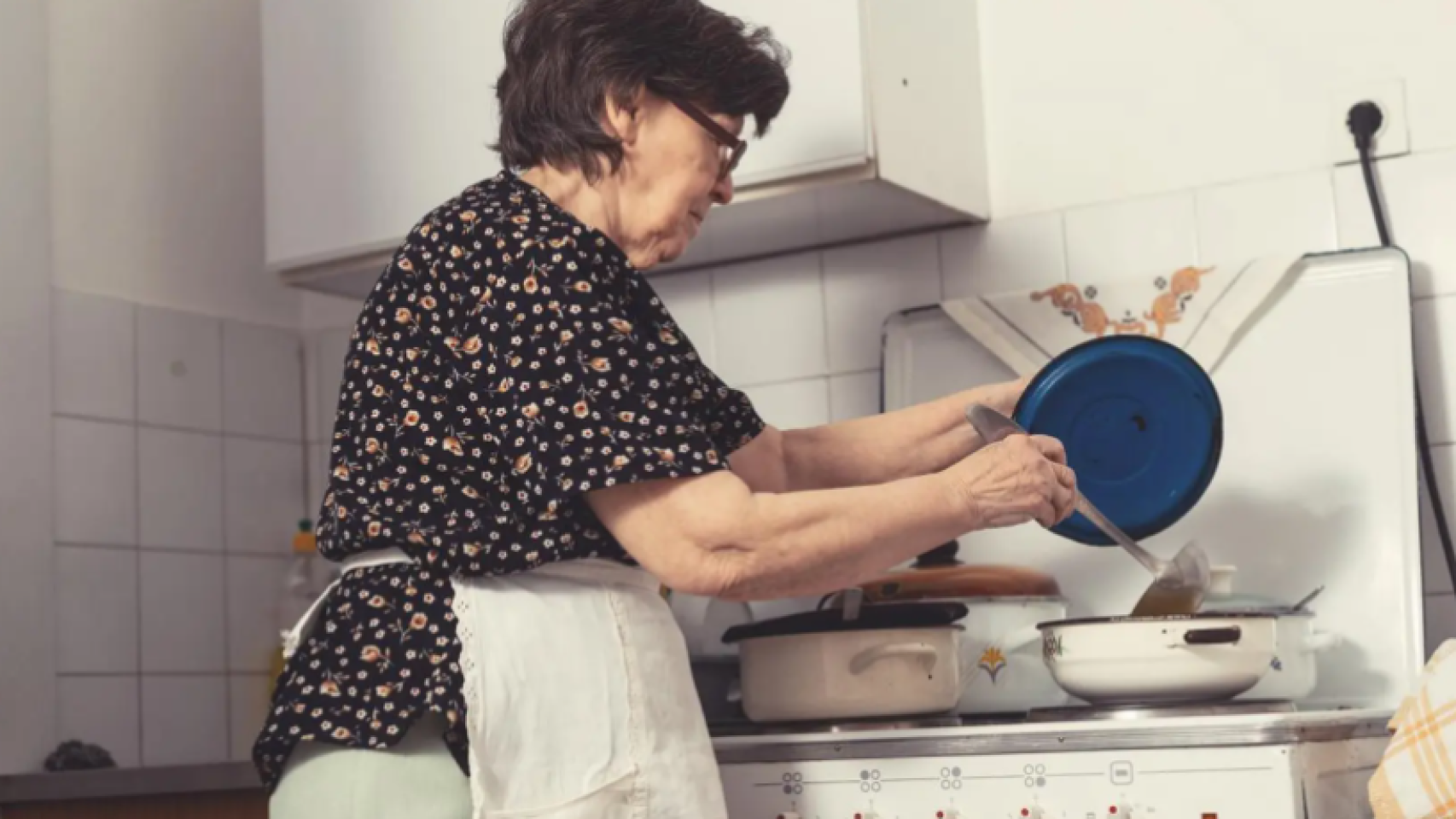 Imagen de una anciana cocinando