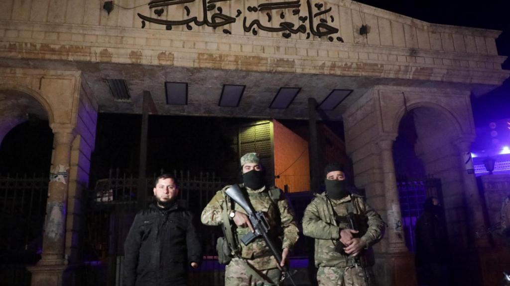 Combatientes de la oposición siria frente a la Universidad de Alepo, tras la llegada de los rebeldes al corazón de la ciudad siria.