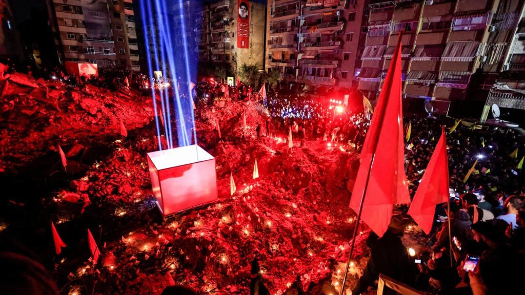 La gente se reúne en un lugar dañado por el ataque aéreo israelí que mató al líder del Hezbolá, Hassan Nasrallá, en Beirut.