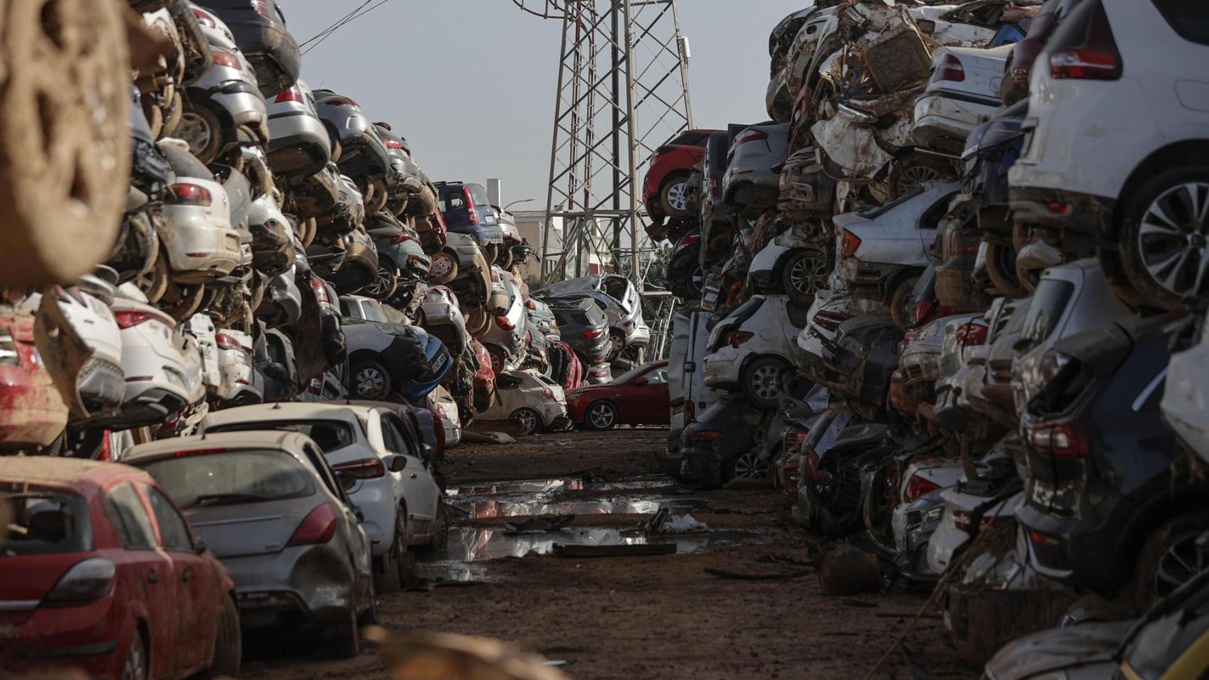 Cientos de coches arrasados por la inundación han sido depositados en un descampado en la localidad de Paiporta